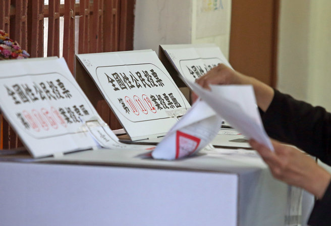 图为2018年九合一选举，民眾拿着大量的公投选票投票。（资料照,赵双杰摄）