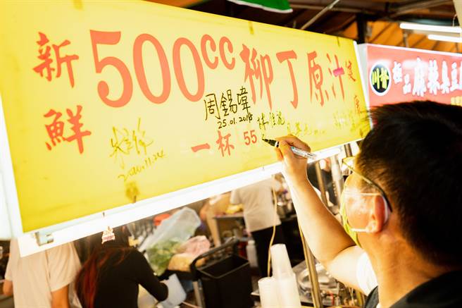 有热情摊商请林佳龙在招牌上签名。（林佳龙竞办提供／李奇叡新北传真）