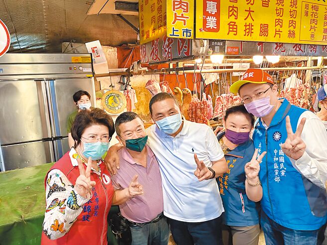 新北市长侯友宜（中）陪同新北市议员陈锦锭（左一）到市场扫街拜票，吸引不少支持者要求合照。（李奇叡摄）