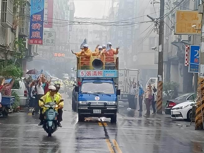 台中市议会议长张清照今天冒着滂沱大雨站在战车上，绕行沙鹿、清水向选民拜票恳托。(张清照竞选总部提供)