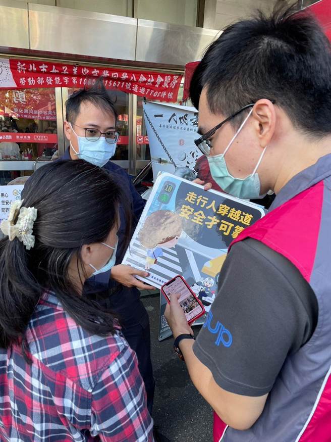 內湖分局員警向民眾宣導反詐騙及交通安全。(翻攝照片／林郁平台北傳真）