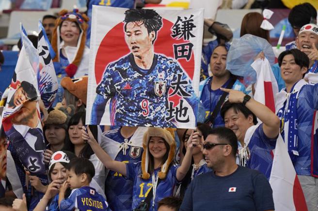 场边日本球迷举出鎌田大地的加油海报。（美联社）