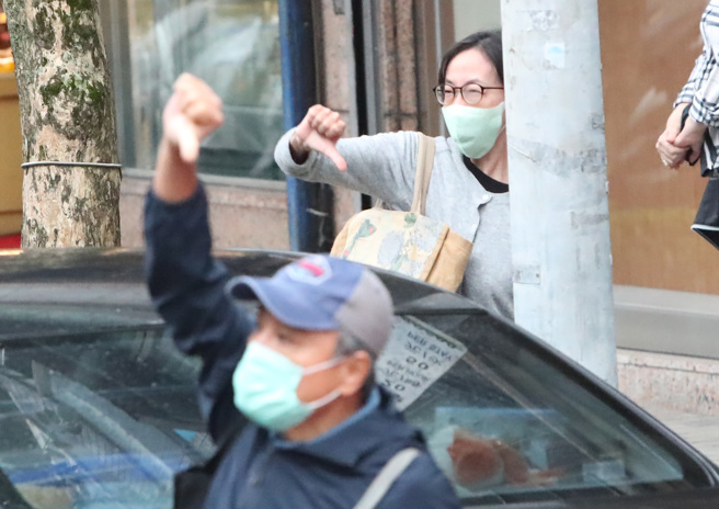 民进党台北市长候选人陈时中23日在前副总统陈建仁陪同下，在北市南港内湖区扫街拜票，遇到不支持的民眾比出倒讚手势。（郑任南摄）