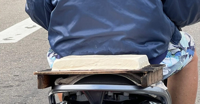 他在街头上看到1名阿伯用装着辅助轮的机车载着1块大豆腐，开玩笑的表示「『拓海老了』仍没忘记用四轮送豆腐」。（翻摄自脸书路上观察学院）