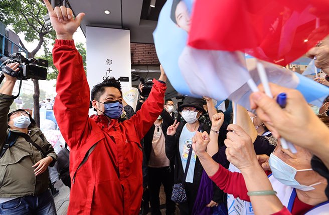 选战进入倒数阶段，国民党台北市长候选人蒋万安（左）24日冒着风雨以车队扫街的方式，争取选民支持，出发前，支持者为蒋加油打气。（陈信翰摄）