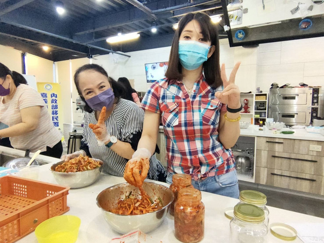 印尼新住民琪燕(右)开心地将做好的泡菜分装置密封罐内保存。(移民署嘉义市服务站提供)