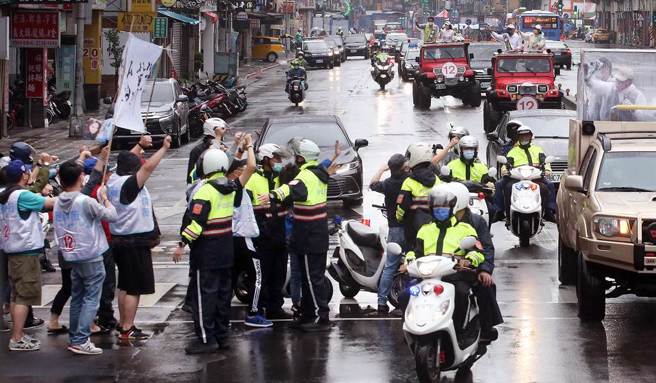 民进党台北市长候选人陈时中（右）24日在中正、万华区扫街拜票，1群民眾高举布条拦路抗议，警方立刻上前隔离双方。（范扬光摄）
