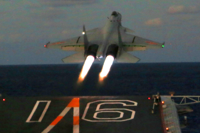 中方海军歼-15舰载战机在「辽寧」舰上进行夜间起降训练的资料照。（新华社）