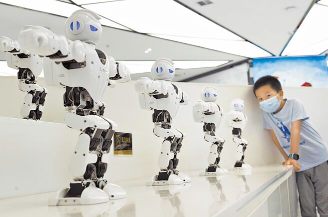 中国企业于电动汽车零组件、电池等13类高科技产品方面，全球市占率呈现增加趋势，凸显全球供应链对于中国的依赖与日俱增。图为在重庆两江机器人展示中心，一名男孩正观看机器人表演。（新华社）