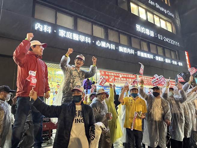 民进党基隆市长候选人蔡适应晚间6时18分举办「牵手护基隆」活动，藉此力挺18岁公民权，眾人冒着大雨站在人行道上举旗讚声，高喊「牵手护基隆」、「点亮基隆」。（黄婉婷摄）