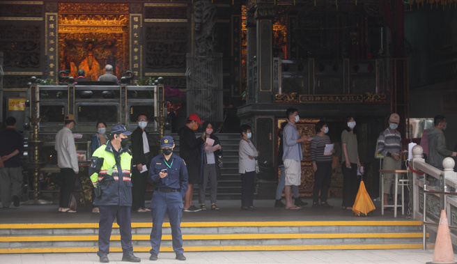 九合一選舉26日投票，地方廟宇也開設了投開票所，民眾排隊投票時也多了一份肅穆的心情。（張鎧乙攝）