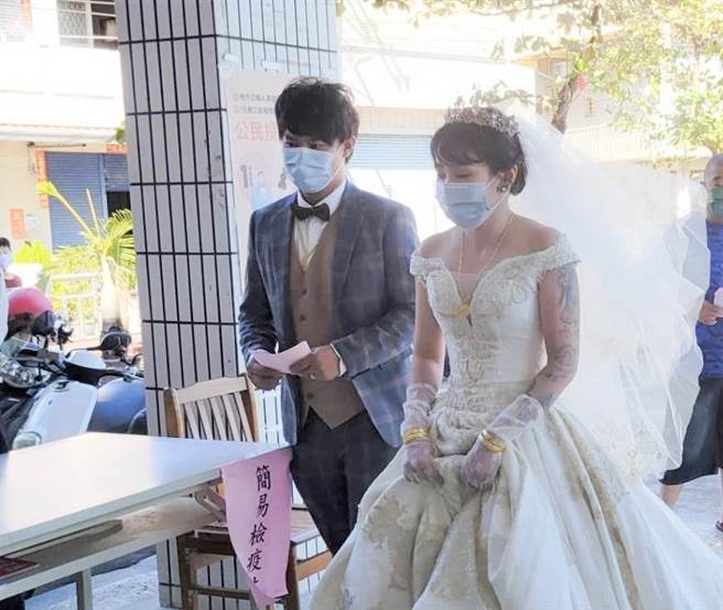 刘培诚（前左）26日带着新娘侯思伊穿着礼服到湖内区刘家里的投开票所投票。（民眾提供／林瑞益高雄传真）