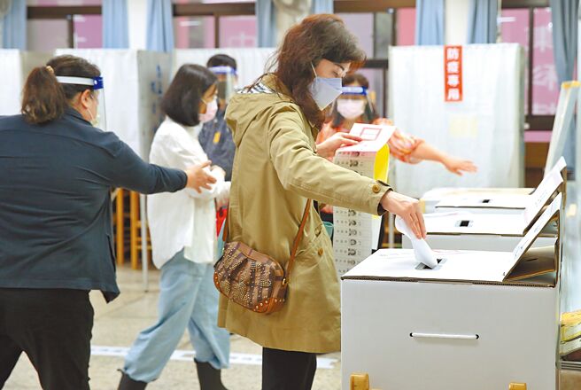 这次九合一地方选举，国民党势如破竹拿下14县市，民进党惨败退缩至5县市。图为九合一选举26日举行投票，民眾一早前往投票所，将圈好的选票一一投入票匦。（陈俊吉摄）