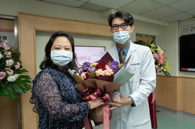 妇产部苏棋枫部长赠花祝吴姓护理人员(左)重获新生。(光田医院提供)