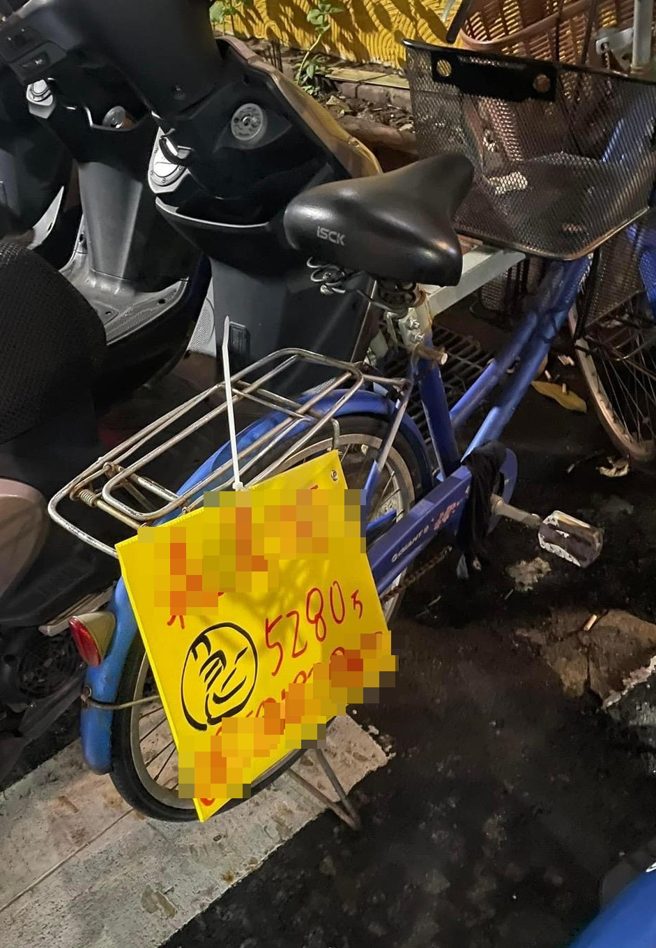 一名网友抱怨自家脚踏车停在路边，车尾竟遭人用束带绑上买房广告看板，只见看板上写着建案名、售价和电话等，该网友痛骂「没水准房仲！」（翻摄自脸书「爆怨公社」）