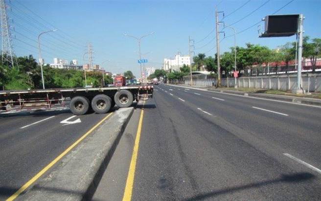 联结车见前方左转车道有停等左转车辆，因此紧急剎车往右侧避撞，导致打滑并碰撞路灯杆打横占据南下车道。（翻摄照片／高雄洪靖宜传真）