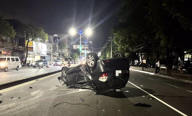 高雄鼎金国中前发生重大车祸，车四轮朝天且车体变形。（崔正纲摄）