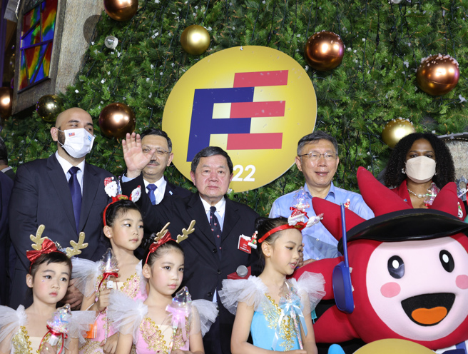 遠東集團29日晚間舉行2022年度耶誕點燈儀式，集團董事長徐旭東（後中）、台北市長柯文哲（後右2）等人出席，開心在耶誕樹前合影。（圖／中央社）