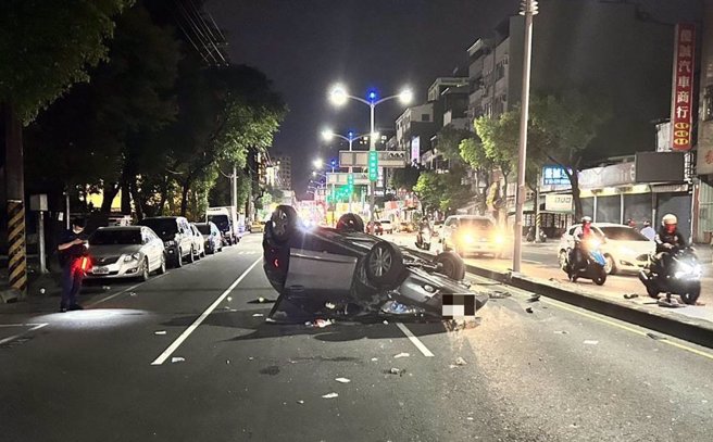 高雄鼎金国中前发生重大车祸，车四轮朝天且车体变形。（崔正纲摄）