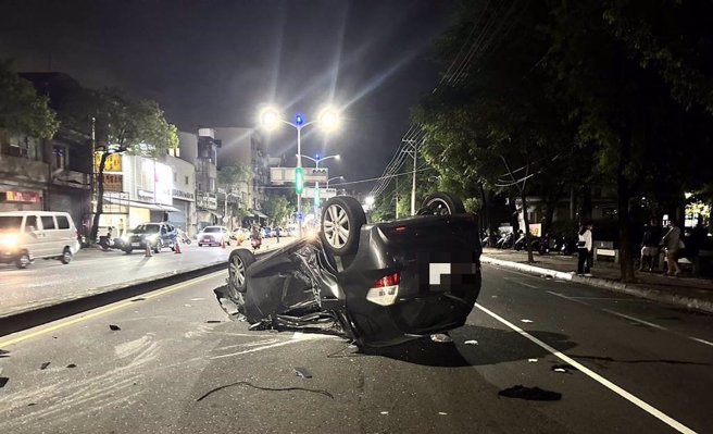 高雄鼎金国中前发生重大车祸，车四轮朝天且车体变形。（崔正纲摄）