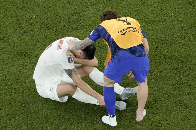 罗宾森安慰伊朗球员。(美联社)