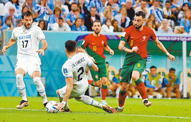 葡萄牙B.费南德斯（右）突入禁区，造成乌拉圭中后卫吉曼奈兹手球犯规。（路透）