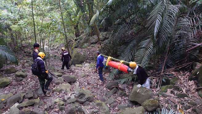 嘉义市救难协会及特搜队员在崎岖山路耗费8小时,轮流将遗体背下山。(翻摄嘉义市救难协会脸书)

