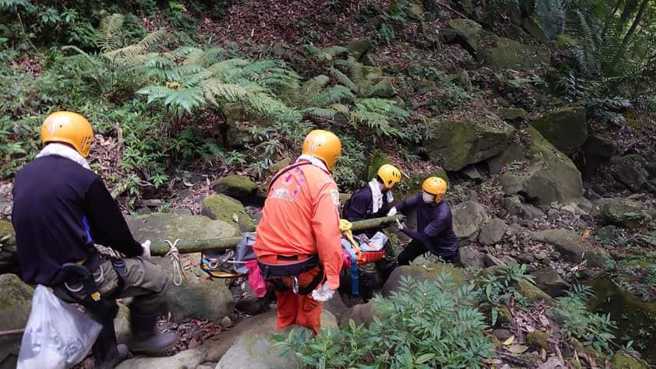 嘉义市救难协会及特搜队员在崎岖山路耗费8小时,轮流将遗体背下山。(翻摄嘉义市救难协会脸书)

