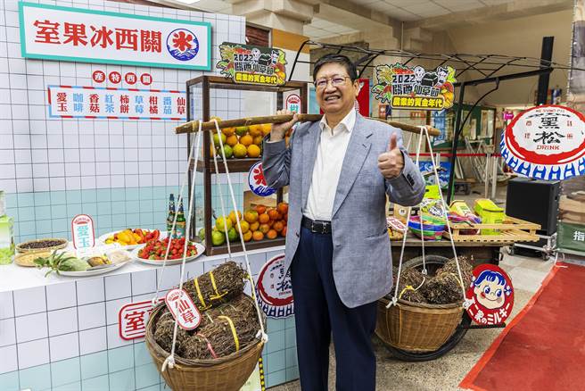 關西仙草節今年走復古風，縣長楊文科挑起盛滿仙草乾的扁擔，體驗懷舊風情。（羅浚濱攝）