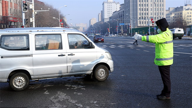 乌鲁木齐将有序恢復超商饭店等经营低风险区可跨区活动。图为1日乌鲁木齐市交警在路上指挥交通。（人民视觉 ）