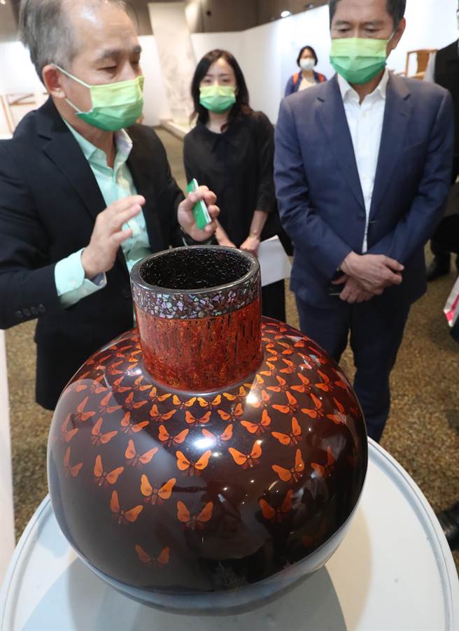 李永得部长参观展场，现场欣赏1999年的得奖作品「蛾舞」，创作者王贤民以完整的漆工艺在柱型球瓶呈现一场华丽的群蛾逐光之舞。（郑任南摄）