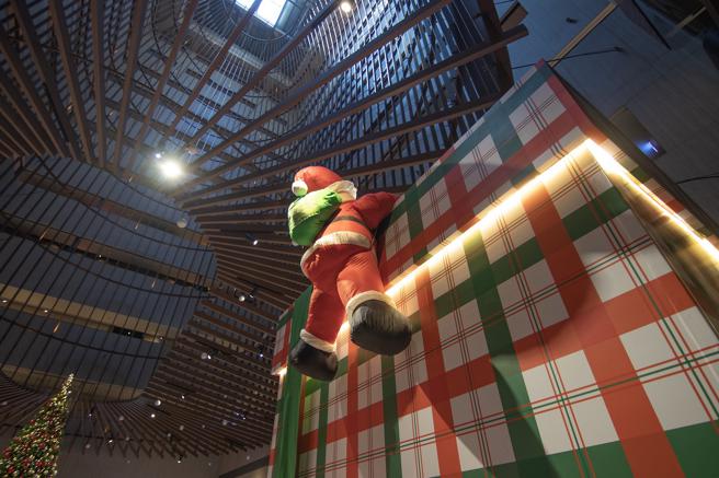 台南大皇冠假日酒店大廳還有巨型耶誕老公公攀爬禮物盒的逗趣造景。（台南大皇冠假日酒店提供）