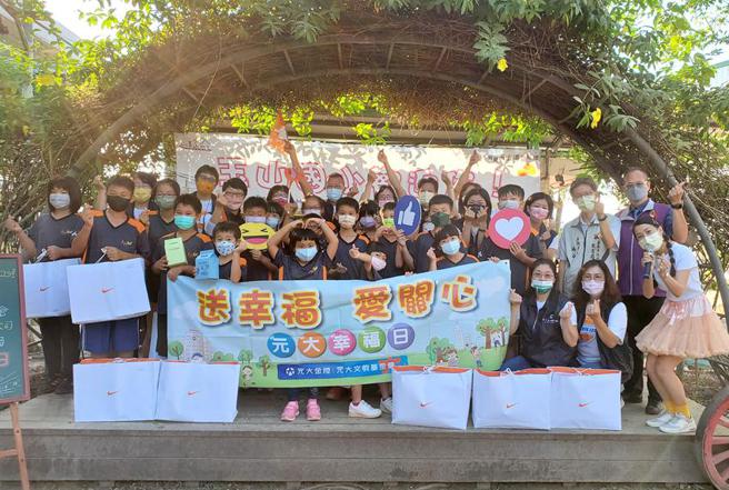 玉山國小學童拿著幸福大禮包開心與元大志工合影。圖／元大金控提供