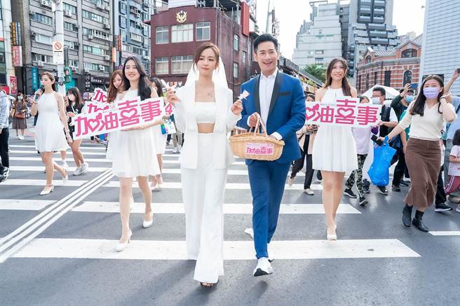 周晓涵、周孝安快闪沿街发喜糖，为新戏《加油喜事》宣传。（TVBS提供）