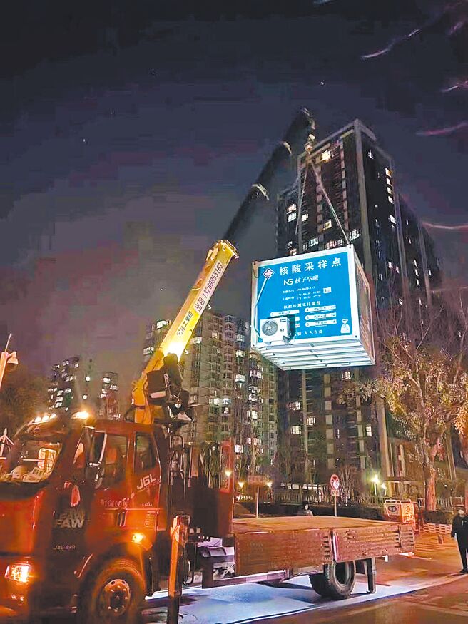 大陆多地放松防疫措施，北京市一处核酸检测亭半夜被机具吊离。（摘自微博）