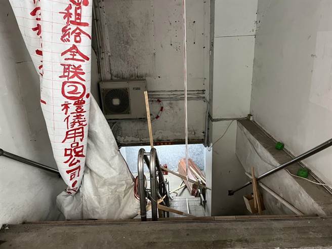 苏男因违规装潢遭检举，竟在社区出入口旁悬挂抗议布条，并放置一具棺材藉此骚扰住户。（警方提供）