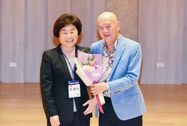 「五金皇后」特力董事长李丽秋获颁杰出校友奖，特力总裁何汤雄惊喜献花。图／特力集团提供