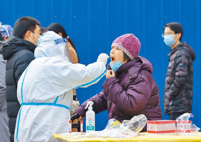大陸疫情防控持續鬆綁。圖為北京一處街頭常態化核酸檢測點，市民排隊接受檢測。（中新社）