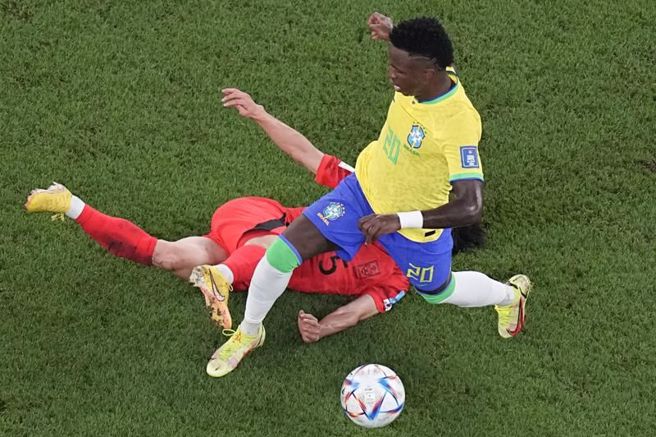韩国后卫金纹奂倒地铲球，仍被巴西前锋小维尼修斯闯过。（美联社）