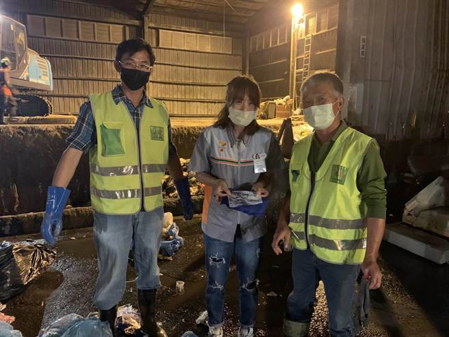 清洁队员在成堆垃圾山中，找到蓝色垃圾袋内的现金收纳袋，经清点现金1万5000元无误。(台中市政府提供)