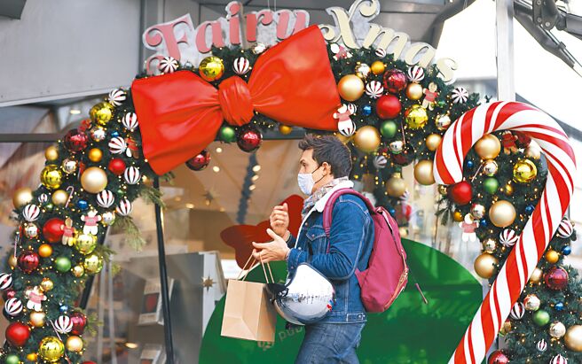 法國總統馬克宏日前在美國華府進行的國是訪問的第一天，就批評美國為支持本土製造商而提供的補貼對法國企業相當不利。圖為在法國巴黎香榭麗舍大街，一名男子走過一處聖誕裝飾。（新華社）