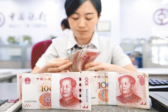 人民幣兌美元在岸、離岸匯價5日雙雙升破7元大關、闊別3個多月後重回「6元」時代。圖為山西太原，銀行工作人員正在清點貨幣。（中新社）