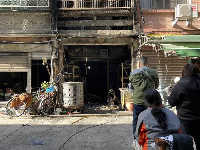 女屋主（长髮）看着房子全被烧得焦黑，她哭得双眼通红。（洪靖宜摄）