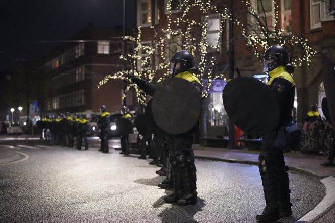 荷兰阿姆斯特丹镇暴警察列队看管摩洛哥球迷。（美联社）