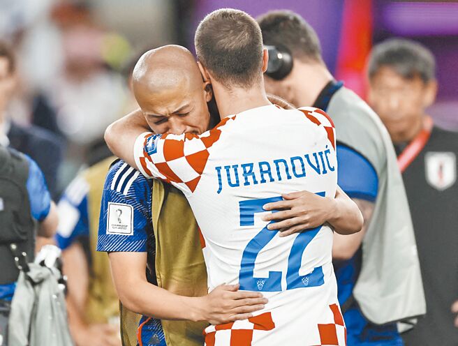 日本前锋前田大然（左）在落败后痛哭，他的苏超塞尔提克队友、克罗埃西亚后卫祖拉诺维奇上前拥抱安慰。（路透）