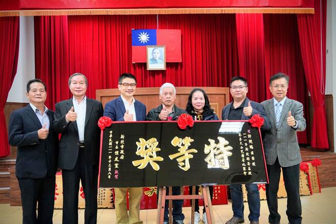 石碇区冬季包种茶评鑑比赛，石碇茶农许闵瑞获特等奖，父亲许茂松(左四)代为领奖，农业局长李玟(左三)颁发匾额恭贺。（农业局提供）
