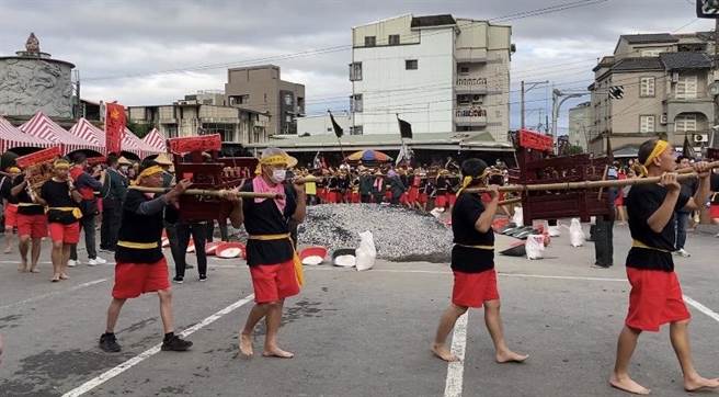 神轿过火前，信徒扛轿绕行炭火堆热身。（吴佩蓉摄）