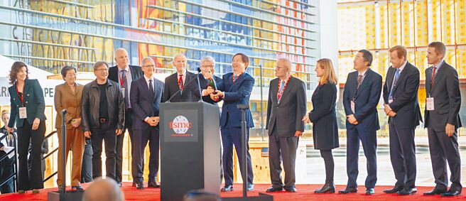 台积电亚利桑那州5奈米制程的12吋晶圆厂「Fab 21」7日举行首批机台设备到厂移机典礼，台积电董事长刘德音（右六）及总裁魏哲家（左七）一起开香槟庆祝，包括台积电创办人张忠谋（右五）、苹果公司执行长库克（左五）等贵宾共同见证。（台积电提供）