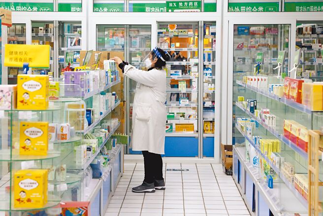 大陆近日多地实施防疫放宽与优化，股市呈现庆祝行情，与防疫开放相关的医药产业掀起涨停潮。图为北京一家药局的工作人员忙着整理商品。（中新社）