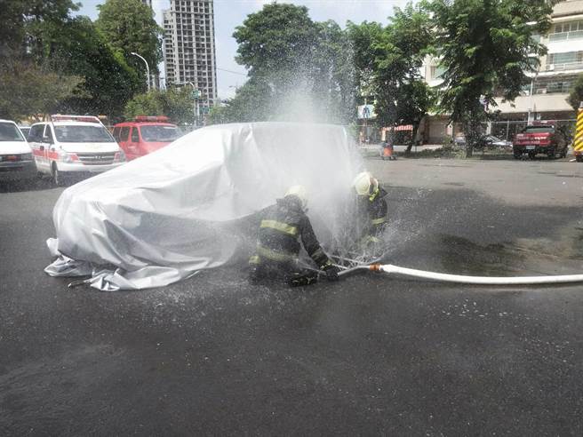 滅火毯在覆蓋起火的車體。（翻攝照片／高雄洪靖宜傳真）